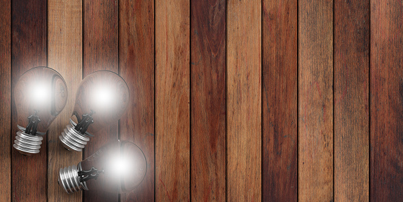 3d rendering three light bulbs on wooden background
