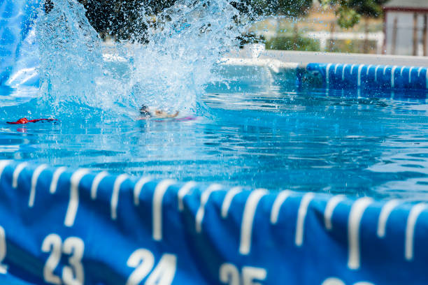 istock Dog making a big splash jumping in pool to retrieve ball 1048650036
