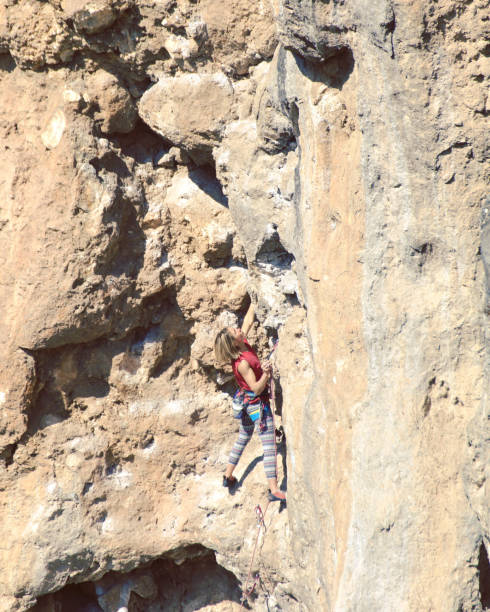 istock Young female rock climber on a cliff face. 1048653546
