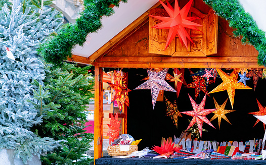 Paper Christmas star decoration at Christmas Market in Winter Berlin, Germany. Advent Fair and Stalls with Crafts Items on the Bazaar.