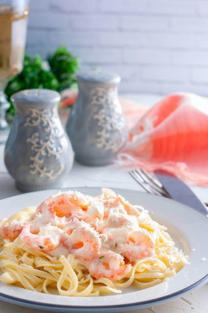 istock Pasta with shrimps in a creamy sauce on a white plate, selective focus 1048657858