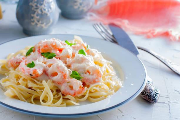 istock Pasta with shrimps in a creamy sauce on a white plate, selective focus 1048659926
