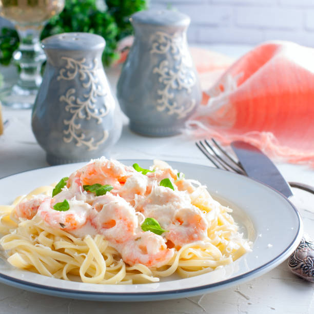 istock Pasta with shrimps in a creamy sauce on a white plate, selective focus 1048659944