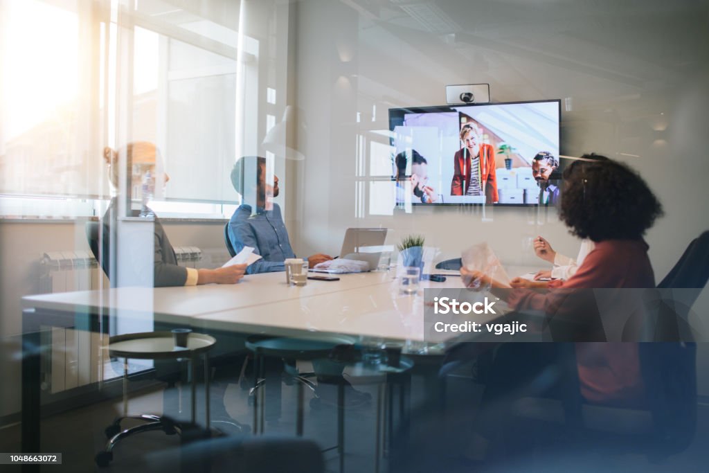 Business Meeting Group of young business people discussing with colleagues  on video conference on meeting. Video Conference Stock Photo