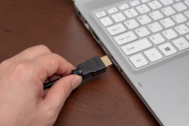 istock Man is connecting black hdmi cable into laptop. 1048664074