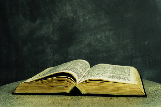 istock Bible on a round white table. Beautiful dark background. Religious concept. 1048669262