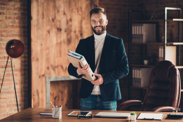 istock Classic elegant cheerful smart clever intelligent content bearded handsome attractive business shark, ceo, leader in black jacket, holding folder at workplace, workstation 1048677392