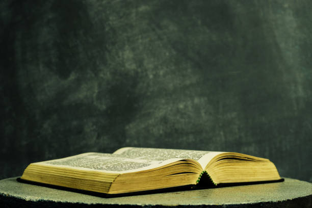 istock Bible on a round white table. Beautiful dark background. Religious concept. 1048683760