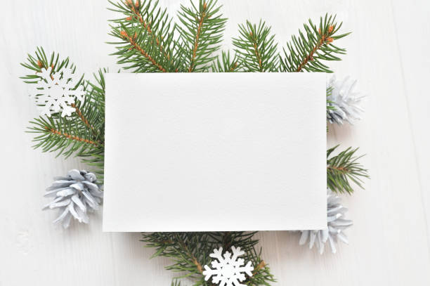モミの枝、コーンの白いクリスマス背景に紙の空の白いシート。クリスマスの手紙のモックアップ。フラットは、あなたのテキストのための場所で白い木製の背景に横たわっていた。トップ  - christmas paper 写真 ストックフォトと画像