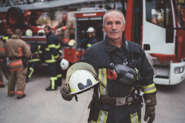 Firefighter's portrait Firefighter with work helmet under arm looking at camera 60 69 years stock pictures, royalty-free photos & images