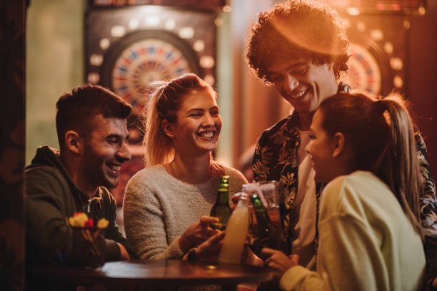 istock Young cheerful friends toasting after playing darts in a bar. 1048690904