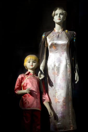 Two manikins in a store front in China town.