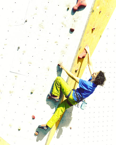 istock Man bouldering at an indoor climbing centre. Climber practicing rock climbing at an indoor climbing gym. 1048695898
