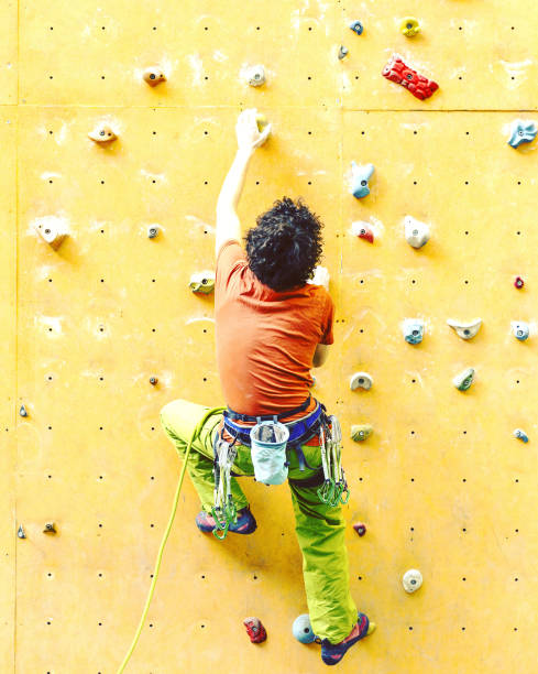 istock Man bouldering at an indoor climbing centre. Climber practicing rock climbing at an indoor climbing gym. 1048695902