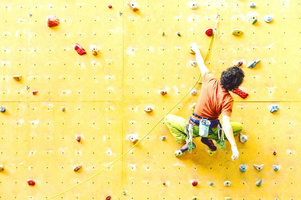istock Man bouldering at an indoor climbing centre. Climber practicing rock climbing at an indoor climbing gym. 1048695932