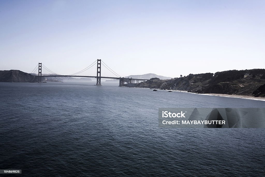 Golden Moody sky over the Golden Gate Bridge in San Francisco. Bay of Water Stock Photo