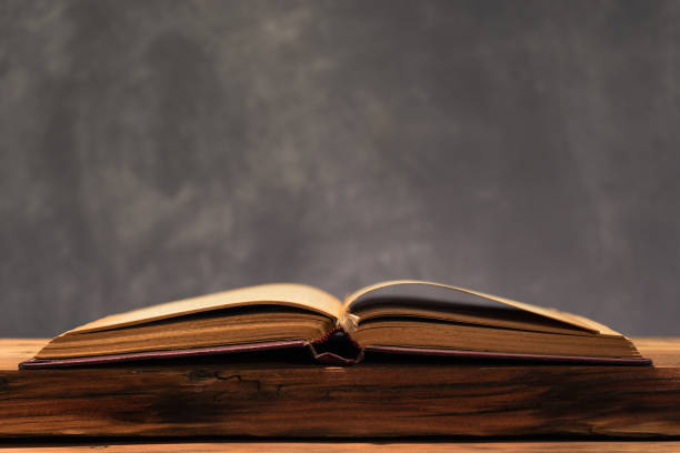 istock Old book on a old oak wooden table. Beautiful dark background. 1048698724