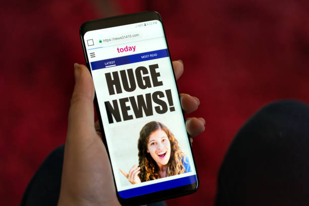 istock Hand holds phone showing message: Huge news! 1048702720