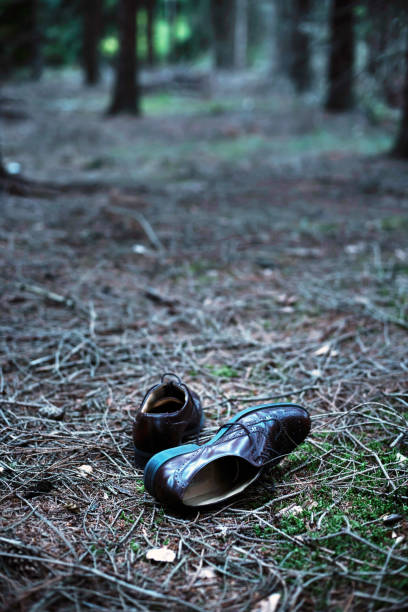 Pair of male shoes on forest path.