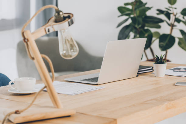 istock laptop, documents and lamp on wooden table in office 1048724648