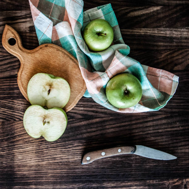 istock Sliced apples on a wooden board with a knife 1048741144