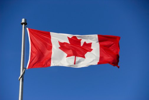 An Alberta and Canada flag waving.