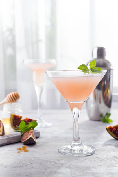 istock The rose exotic cocktail and figs, honey on light background over windows, copy space 1048760360