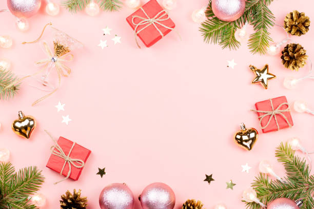 istock Christmas background with fir branches, lights, red giftboxes, pink decorations, hot drink with marshmallows on pink 1048760880