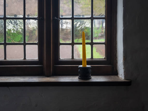 istock The candle in a candlestick on windowsill 1048779428