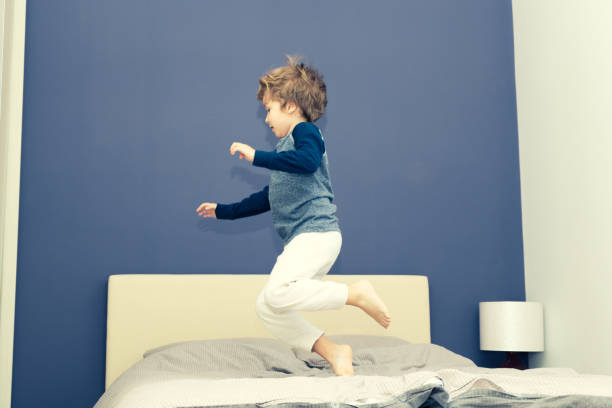istock Playful kid in pajamas having fun in bedroom. 1048781726