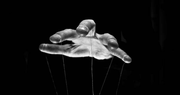 Eerie puppeteer hands controlling you. Manipulation concept We are being manipulated concept. Large scary hands with puppet string tied around fingers puppet master stock pictures, royalty-free photos & images