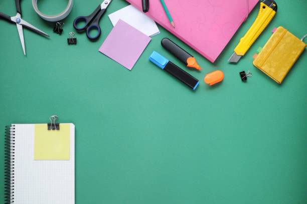 istock Study stuff. Education background. Stationery. Aspects of education. Pencil, papers, markers, scissors, folder, scotch tape, clips and notebook on the table. 1048789992