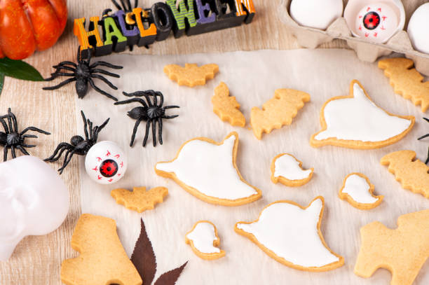 istock Fresh homemade decorating halloween cookies with ghost, creeping spider, bat, haunted castle and horrifying eyeball on wooden background, copy space 1048793318