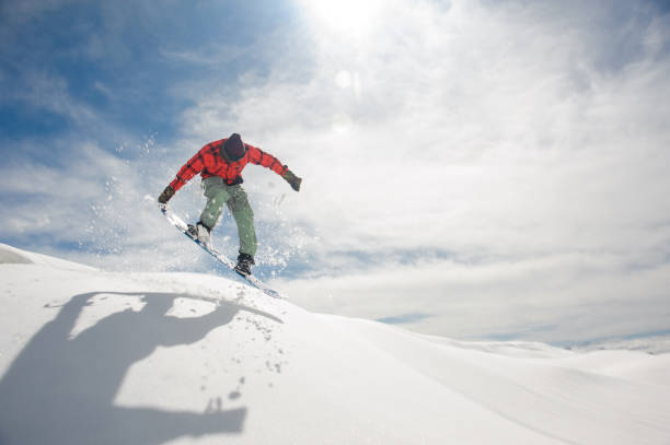 istock Jumping snowboarder keeping hand on the snowboard on the amazing background 1048803208