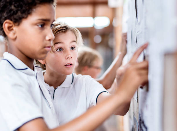 istock Male students checking list on bulletin board 1048803442