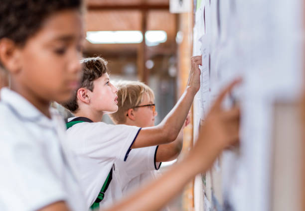 istock Male students checking list on notice board 1048803446