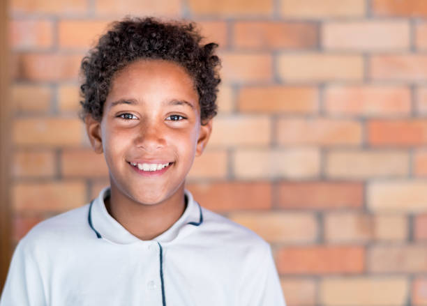 porträt eines schülers gegen mauer stehend - pre teen boy stock-fotos und bilder