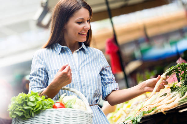 istock Young woman buying vegetables 1048814948