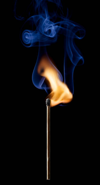 Ignition of a match, with smoke on dark background stock photo