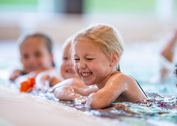смеющаяся девушка в бассейне - swimming child swimming pool indoors стоковые фото и изображения