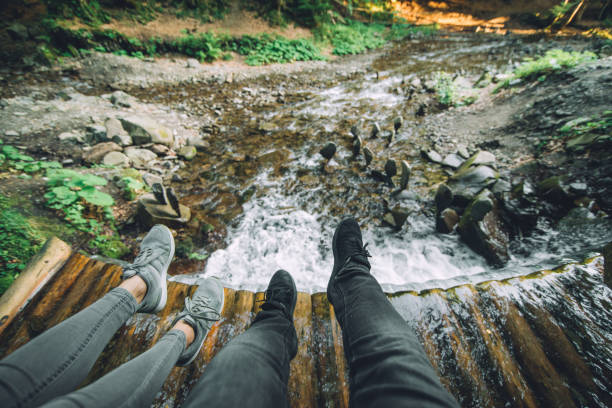 istock legs of two persons with waterfall on background 1048821934