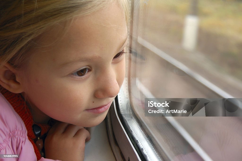 Niña mirando a través de la ventana del tren - Foto de stock de Mirar por la ventana libre de derechos