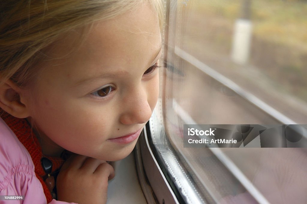 Dziewczynka patrzy przez okno pociągu - Zbiór zdjęć royalty-free (Dziewczyny)