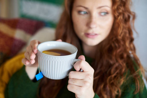 istock Woman's hands holding a cup of hot tea with lemon 1048835414