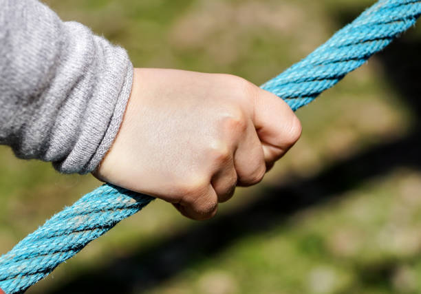 istock Children hand catching the rope with sunny day. 1048835502