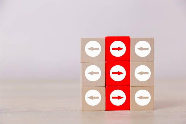 Red wooden blocks with white arrows facing opposite to the white arrows. With different concepts to other people. Going for success.