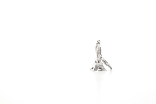 Key chain in the shape of Eiffel Tower on white background, European holiday ideas