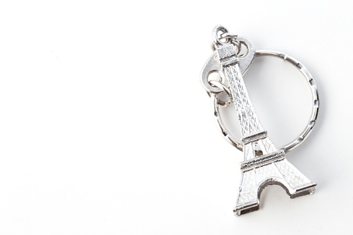 Key chain in the shape of Eiffel Tower on white background, European holiday ideas