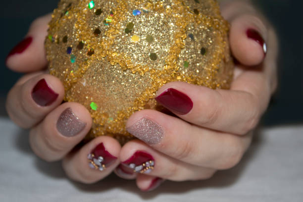 istock Female hands holding a gold Christmas ball 1048841754