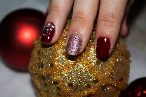 istock Female hand with decorated nails above a gold glitter ball 1048842354